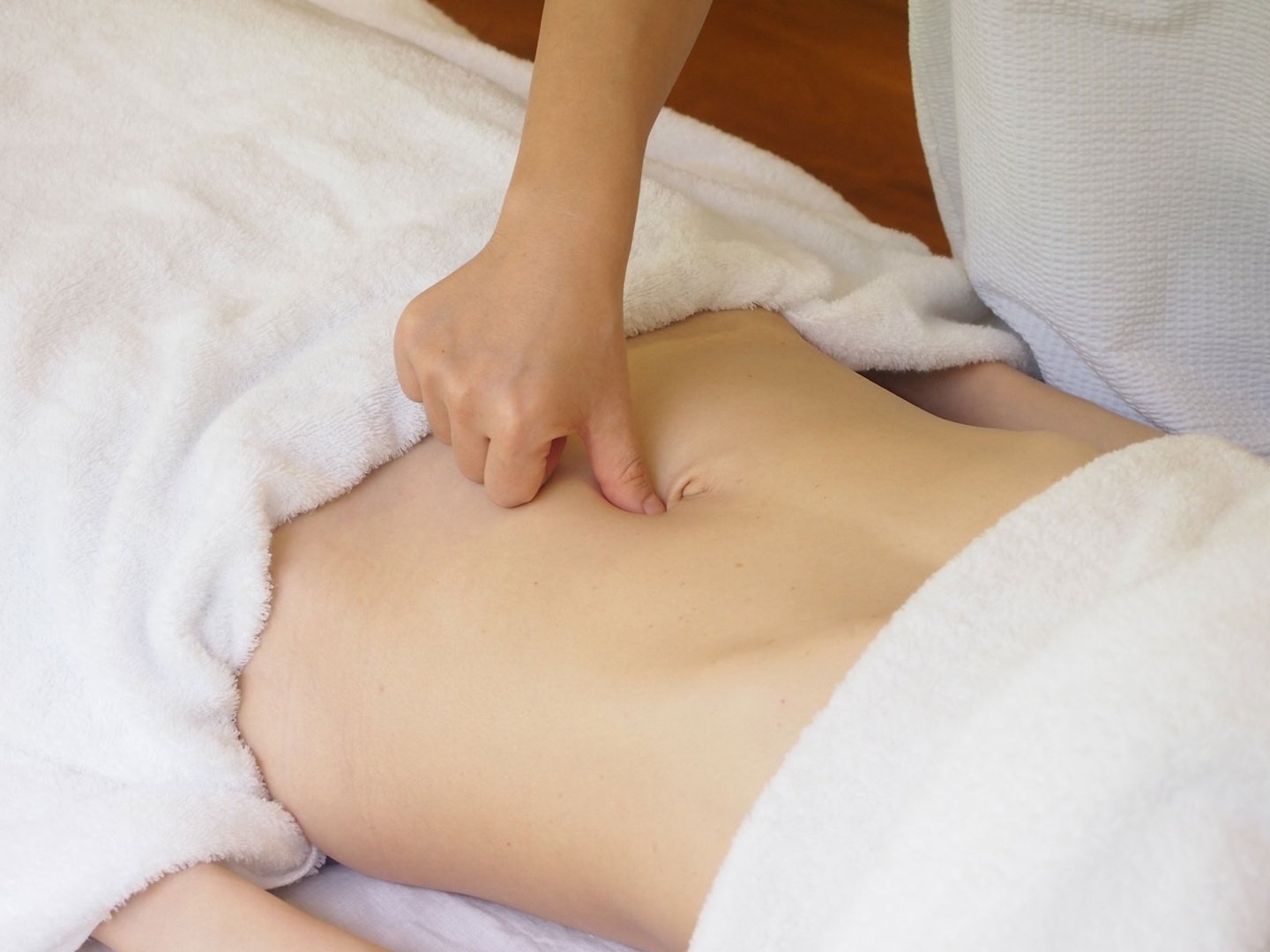 Hands offering gentle abdominal bodywork