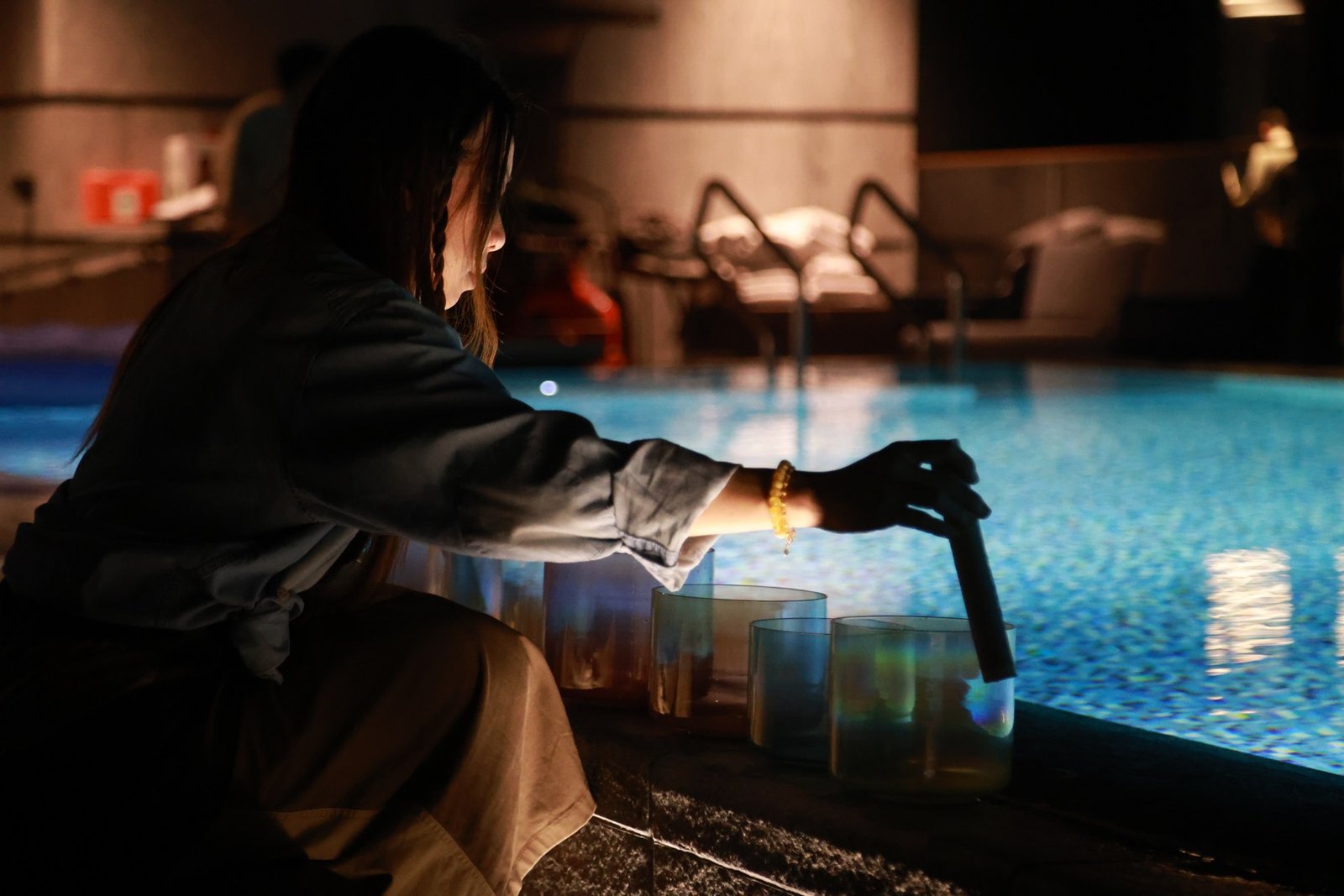 Una playing crystal singing bowls beside water
